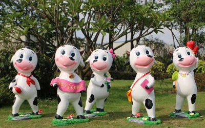 園林一群游玩的玻璃鋼卡通奶牛雕塑